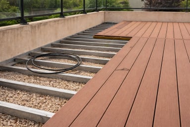 Partially constructed outdoor deck showing wood panels and metal supports.