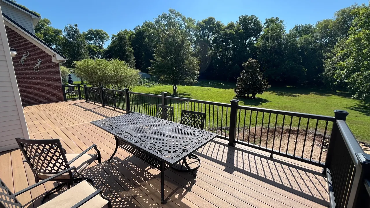 Outdoor deck view with tables and chairs overlooking green landscape